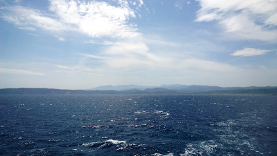 The view of the calm sea. In the distance are low 