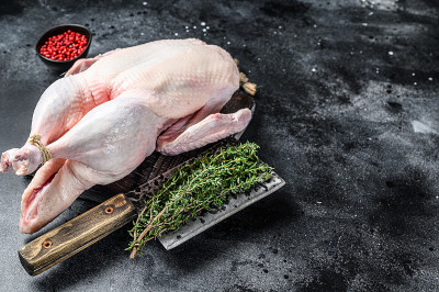 生整鹅、禽肉。黑色背景。前视图。空间的文本