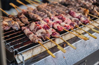 把炉子上的生牛肉串合起来。人行道上的街边小吃