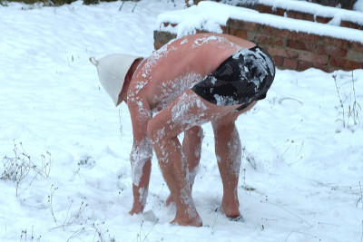 冬天，一名穿着短裤的中年男子在街上擦雪，雪变硬了
