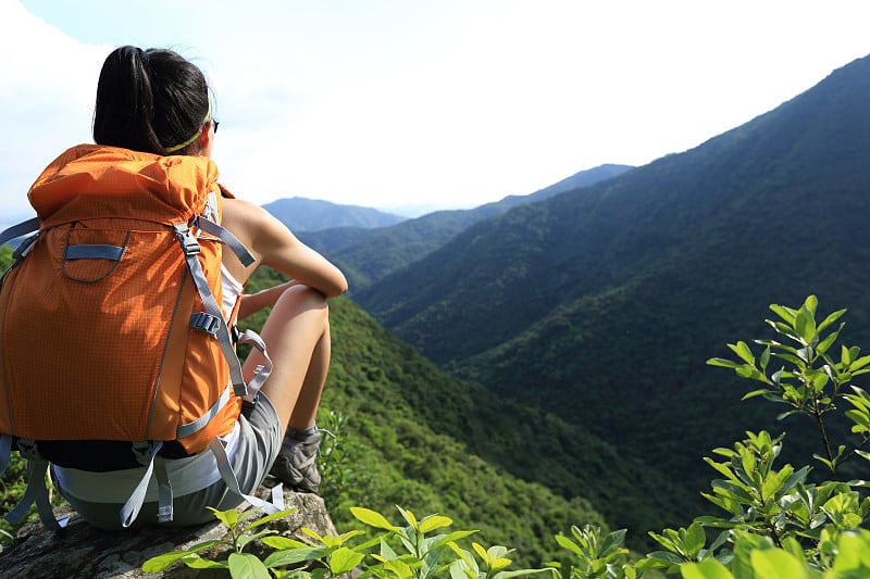 女背包客在欣赏山顶悬崖的景色