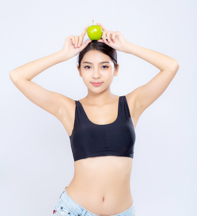 美丽的肖像亚洲女人微笑着抱着绿色的苹果水果和身体节食与fit孤立在白色的背景，女孩体重苗条与脂肪团或