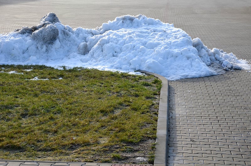 cleaning snow from large areas of parking lots and