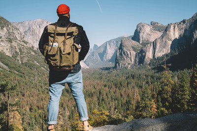 背景的家伙wanderlust在山中徒步旅行站在山顶欣赏风景，男性旅行者与旅游背包到达山顶观察惊人的