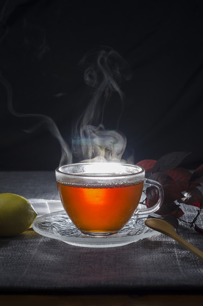 用玻璃杯盛热茶，配以柠檬和香草。随意的背景。茶，咖啡，热饮，
