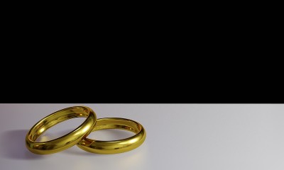 在金属表面上的黄金戒指的3d渲染与反射和黑色背景的爱和浪漫的概念。