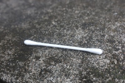 小男孩手里拿着白耳朵清洁剂