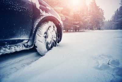 汽车轮胎在被雪覆盖的冬季道路上行驶