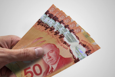 手里拿着加元。CAD。加拿大的货币