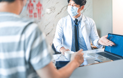 手持医生测量病人的压力。医疗工作者在检查血压或其他健康的年轻人期间。