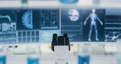 电脑屏幕上的冠状病毒和人体骨骼模型。未来的实验室研究