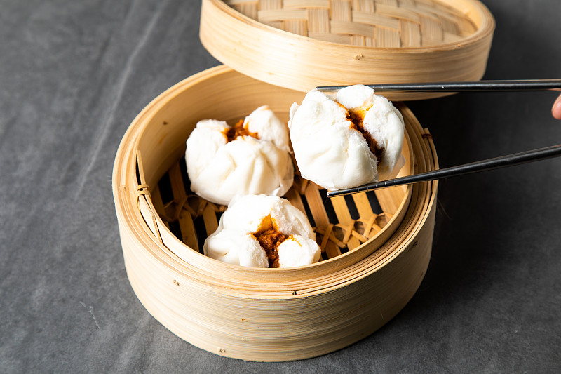 中国传统美食的概念。饺子点心在竹蒸笼内用文字抄写空间。亚洲食物背景