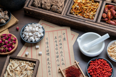 桌上放着古老的中医书籍和药草