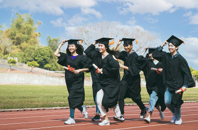 一群庆祝毕业的学生在跑道上跑步