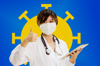 一名亚裔美国医生用冠状病毒演示竖起大拇指