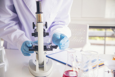 特写女科学家手用滴管在实验室看科学显微镜医学试验，研究生物化学。女性技术员实验室分析血液科学药物研究