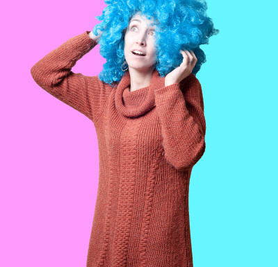 漂亮的女孩，带着蓝色卷曲的假发和高领毛衣