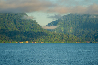 美丽的Maninjau湖全景，西苏门答腊岛，印度尼西亚在蓝色的早晨，与一艘小渔船航行。印尼美丽的自然