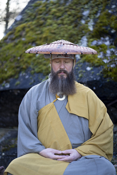 蓄着胡须的欧洲男人穿着传统的日本修道服装进行冥想