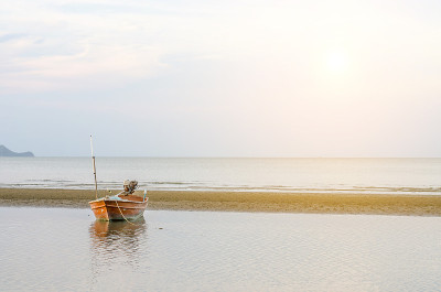 泰国华欣海滩上的小船和夕阳