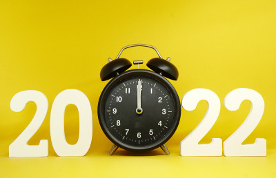 2021年到2022年新年倒计时，数字2022木制字与复古黑色时钟(0时钟)的黄色背景色-节日庆祝概