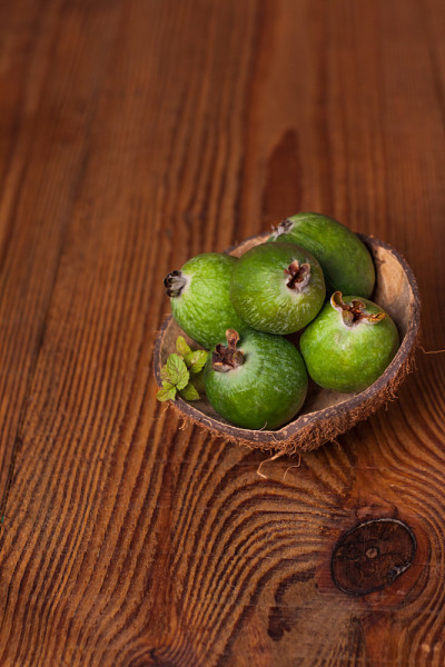 椰壳壳上的青feijoa木背景。成熟的热带水果，生的素食。维生素c拷贝空间。