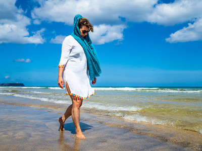 一位中年妇女在海边散步