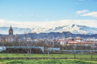 西班牙安达卢西亚格拉纳达省的瓜迪克斯镇和大教堂与积雪覆盖的内华达山脉。