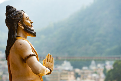 恒河河岸上的印度教雕像令人叹为观止。模糊的Lakshman Jhula桥在背景。北阿坎德邦圣地,印度