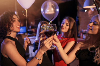 一群欢快的女孩在夜总会聚会，站在一起碰杯