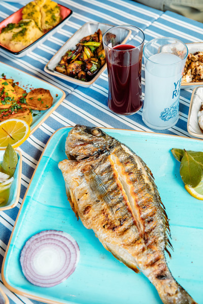 烤鱼、沙拉和蔬菜。海鲜，烤肉，meze, raki, ouzo，开胃菜和沙拉在希腊或土耳其鱼餐厅的桌