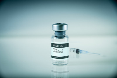 Covid-19疫苗瓶和注射器，蓝色背景
