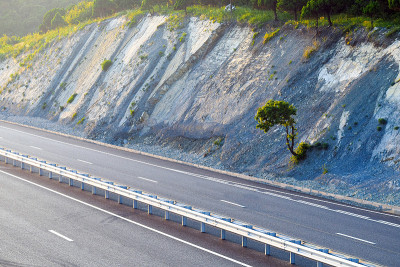 山路，夕阳，护坡上的安全网。防止岩屑、岩崩、滑坡