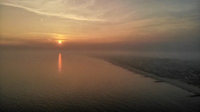 在一个寒冷的秋天夜晚，克赖斯特彻奇的Southbourne海滩上朦胧的日落