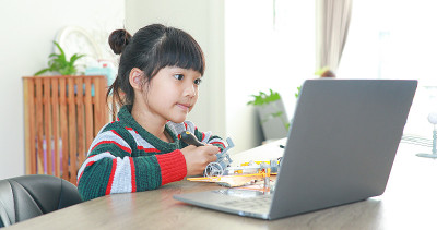 小亚洲女孩在房子里的科学课上建造机器人汽车。它促进了天才儿童的发展，提高了他们的学习技能。