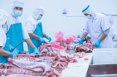 在工厂里切肉的工人