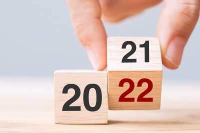 商人手握木制立方体与翻转块2021至2022在桌子背景上的文本。决心，策略，解决方案，目标，业务和新