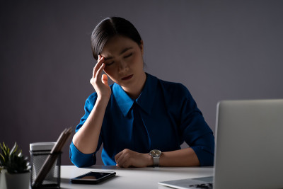 Asian woman in blue shirt was sick with headache w