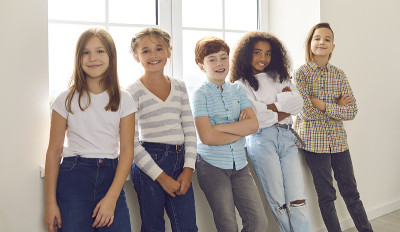 孩子们微笑着站在家里的窗边或在学校休息时