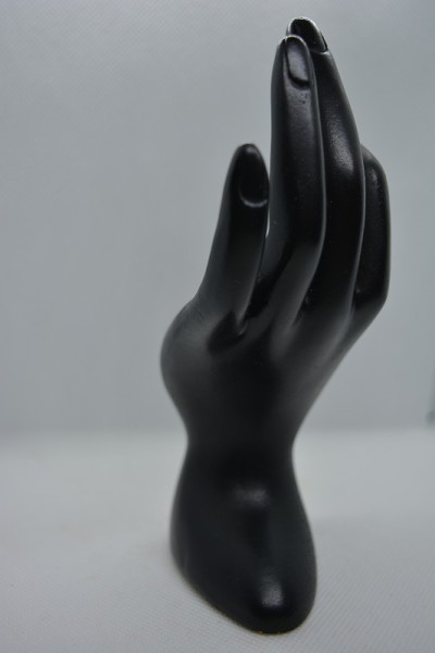 黑色优雅的石雕，彩绘女子的手，用画笔，掌心用一种轻微的辉光定位在黑色的背景上。