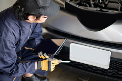 亚洲汽车技师用平板电脑检查汽车