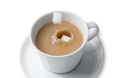 将方糖倒入加牛奶的茶中