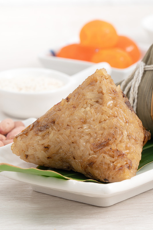 粽子端午节粽子在明亮的木桌背景上配食材。