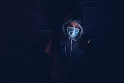 惊恐的男子在智能手机上阅读covid-19冠状病毒信息。
