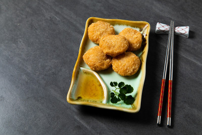 油炸贝类球。中国传统美食的概念。饺子点心在竹蒸笼内用文字抄写空间。亚洲食物背景