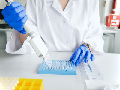 科学家的手工作与多通道移液管和多孔板。基因实验室多管移液管研究技术员。基因和癌症筛查、医疗技术和治疗