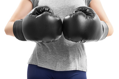 近距离的fit女孩碰撞拳头在拳击手套