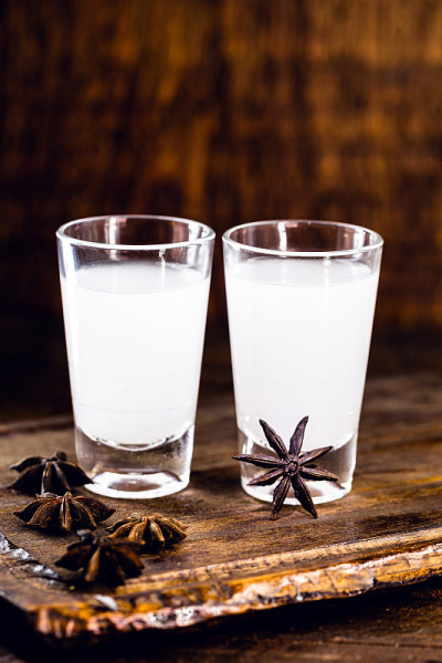 Ouzo或Uzo是一种希腊茴香白兰地，传统的烈性酒精饮料，用玻璃杯盛在旧木桌上。希腊传统，喝神的酒。