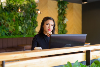 Young beautiful Asian businesswoman thinking while
