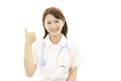 微笑的亚洲女护士竖起大拇指